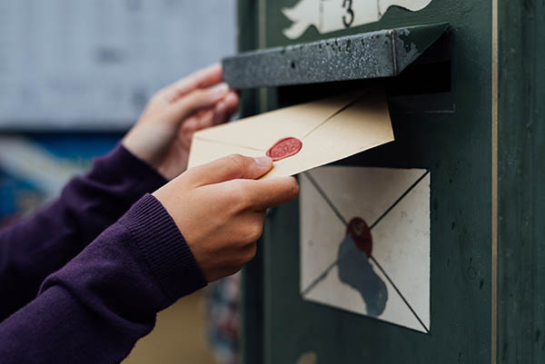 Mailing letter with wax seal to old postbox on street